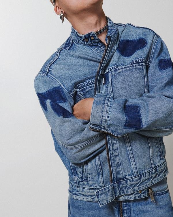 Homem posando em editorial de moda, usando roupas jeans - Metrópoles