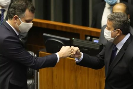 Os presidentes do Senado, Rodrigo Pacheco, e Câmara, Arthur Lira, se cumprimentam no plenário da casa legislativa. Ambos usam máscara e tocam os punhos - Metrópoles