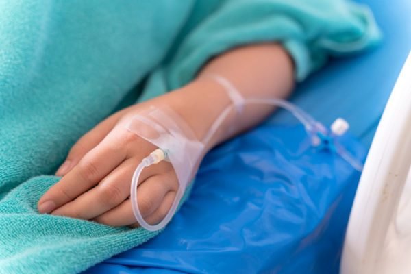 Imagem colorida: paciente em maca de hospital recebe infusão - Metrópoles