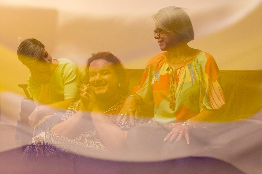 Imagem de bandeira sobreposta a foto de pessoas sorrindo em sofá