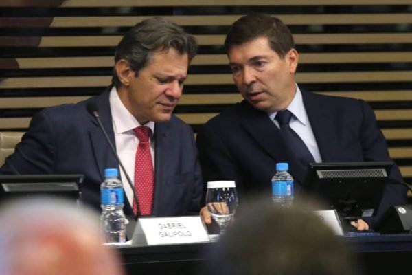 O ministro da Economia, Fernando Haddad, fala em palestra na FIESP, em São Paulo. Ele conversa com Josué Gomes, sentado ao seu lado - Metrópoles