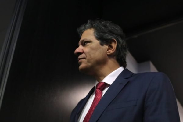 O ministro da Economia, Fernando Haddad, fala em palestra na FIESP, em São Paulo. Ele aparece em pé, caminhando nos corredores do local - Metrópoles