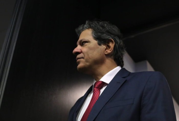 O ministro da Economia, Fernando Haddad, fala em palestra na FIESP, em São Paulo. Ele aparece em pé, caminhando nos corredores do local - Metrópoles