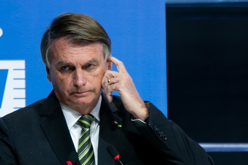 O ex-presidente Bolsonaro em palco de evento do SEBRAE coçando a cabeça - Metrópoles