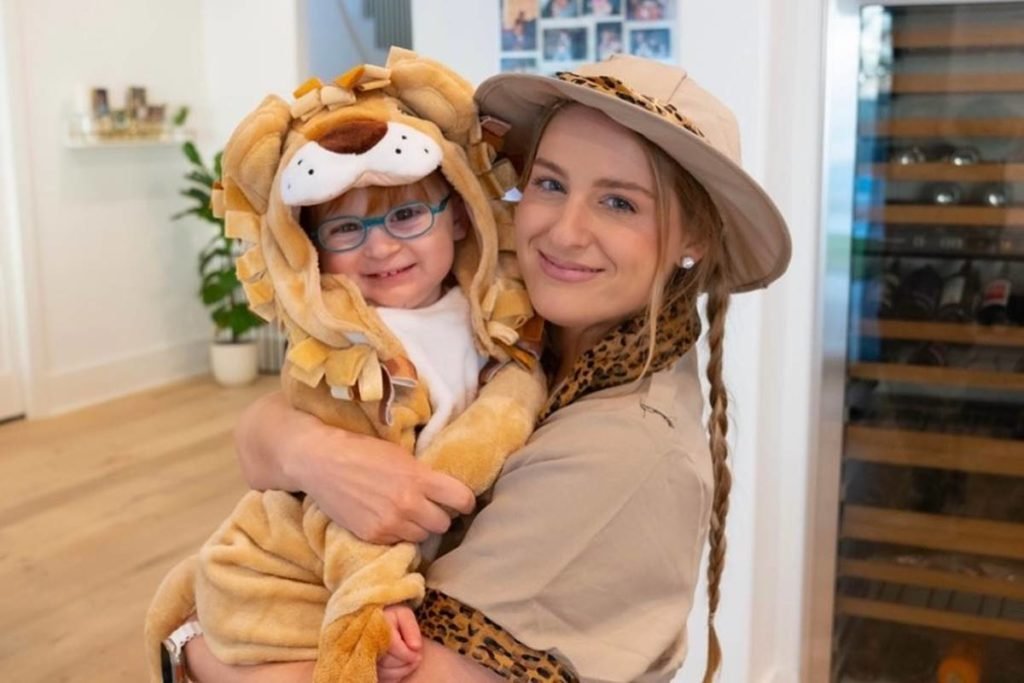 Meghan Trainor com filho riley vestido de leão no colo - metrópoles