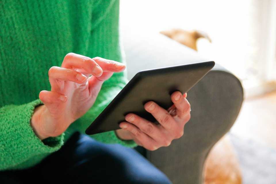 Foto colorida mostra mulher manuseando um tablet. Imagem relacionada com celulares, tablets e redes sociais - Metrópoles