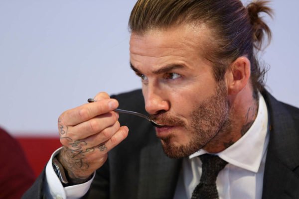 Na foto, David Beckham comendo - Metrópoles