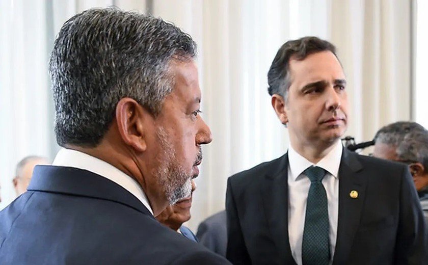 Os presidentes da Câmara, Arthur Lira, e Rodrigo Pacheco, do Senado, olham para o lado postados frente a frente em cerimônia - Metrópoles