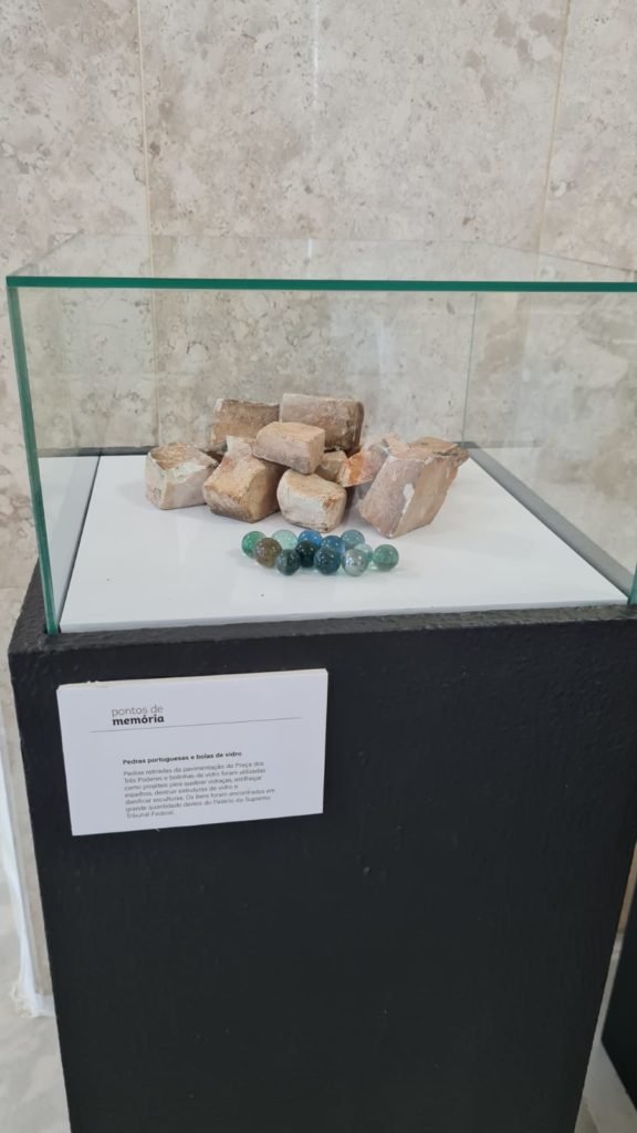 Exposição no plenário do STF com escombros e materiais danificados após invasões antidemocráticas feitas por bolsonaristas em janeiro. No detalhe, pedras e bolas de gude dentro de caixa de vidro - Metrópoles
