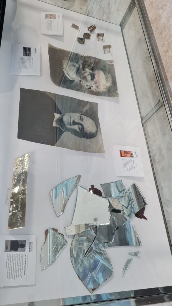 Exposição no plenário do STF com escombros e materiais danificados após invasões antidemocráticas feitas por bolsonaristas em janeiro. No detalhe, espelhos, fotos de autoridades e placas depredadas expostas em caixa de vidro - Metrópoles