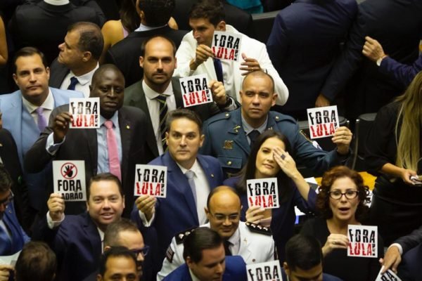 Deputados bolsonaristas posam para foto protestando contra o presidente Lula com placas escrito "Fora Lula" no plenário da Câmara dos Deputados, em dia de posse do poder legislativo. - Metrópoles
