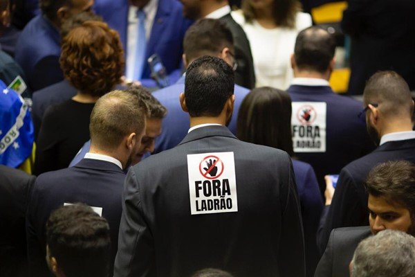 Deputados bolsonaristas posam para foto protestando contra o presidente Lula com placas escrito