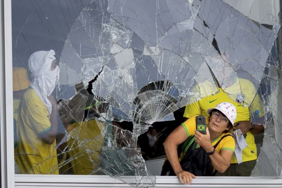 imagem colorida de mulher saindo do vidro dos prédios atacados nos atos de 8 de janeiro - Metrópoles