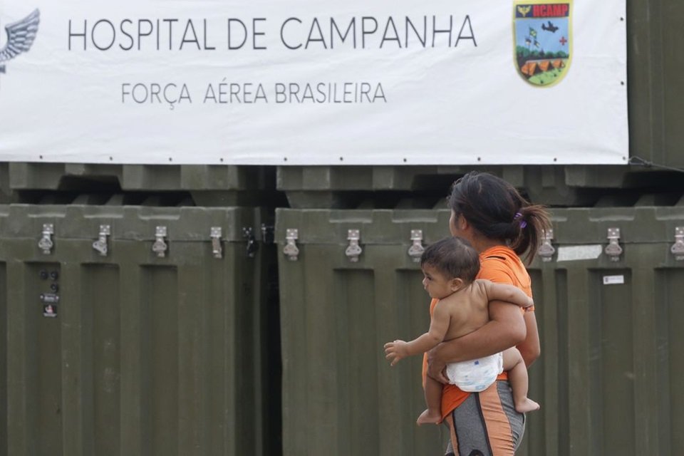 Jovem yanomami segura bebê no colo - Metrópoles