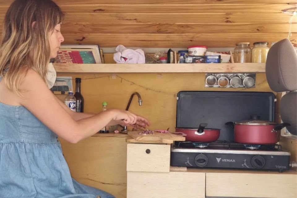 Jovem cozinhando em uma kombi