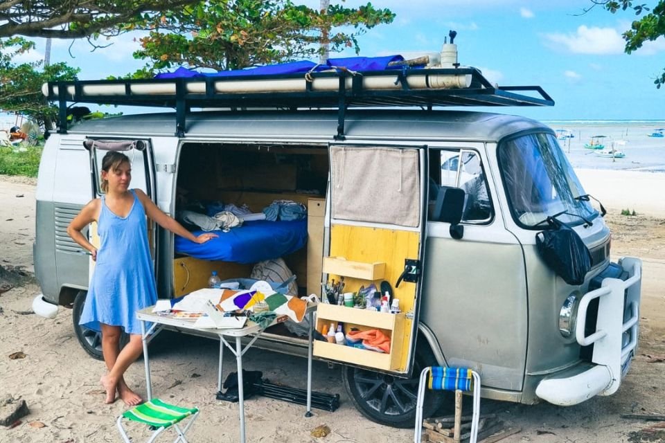 Pamela em frente a kombi na praia