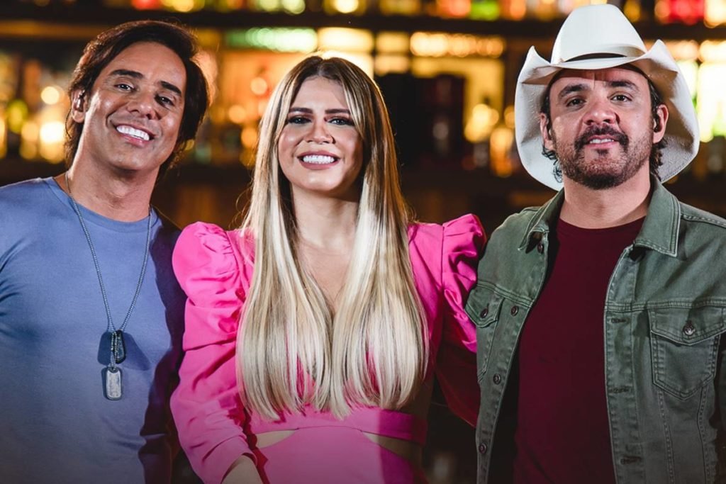 Foto colorida de Guilherme e Santiago e Marília Mendonça em gravação de DVD