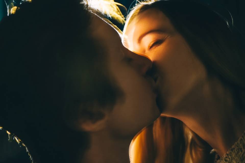 Foto colorida de casal se beijando em close - Metrópoles