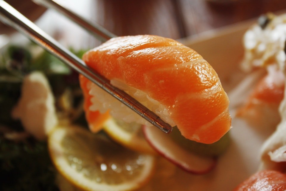 Na foto, um sashimi segurando por um hashi - Metrópoles