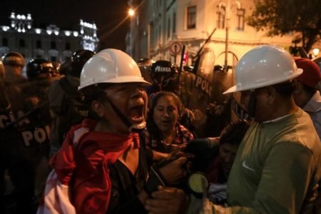 Foto colorida de mulher gritando em frente a policiais em Protesto em Lima no sábado, dia 4 de fevereiro