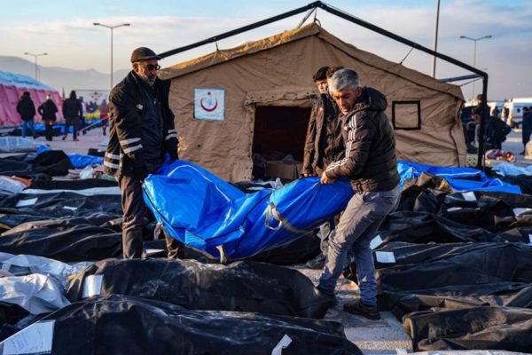 Imagem colorida mostra Sacos de corpos em frente a hospital de Hatay, na Turquia. Como não foi possível encontrar sacos para todos os mortos, alguns foram cobertos com cobertores, após terremoto - Metrópoles