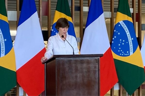 Catherine Colonna, chanceler francesa, fala em púlpito diante de bandeiras do país e do Brasil durante passagem por Brasília - Metrópoles