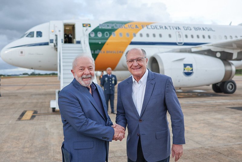 Lula embarcando para a Argentina no VC-1 da FAB, tradicional avião presidencial e apertando a mão do vice, Geraldo Alckmin. Eles sorriem para foto - Metrópoles