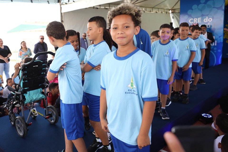 A governadora Celina Leão entrega uniformes com modelo novo para alunos da rede pública. No detalhe, garotos se enfileram em palco exibindo a roupa nova, em espécie de desfile - Metrópoles
