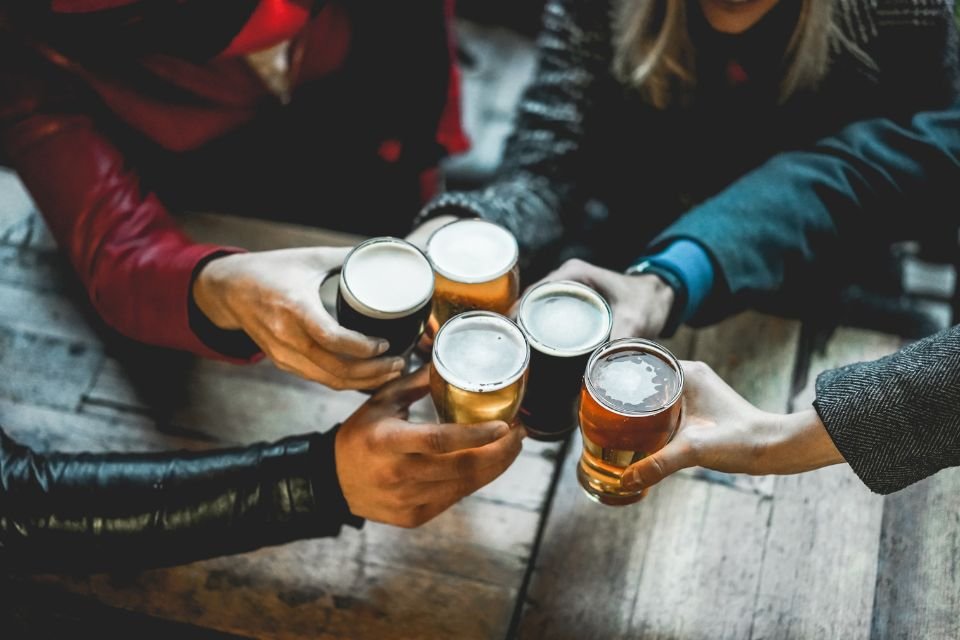 Imagem mostra grupo de amigos brindando com copos cheios de cerveja - Metrópoles