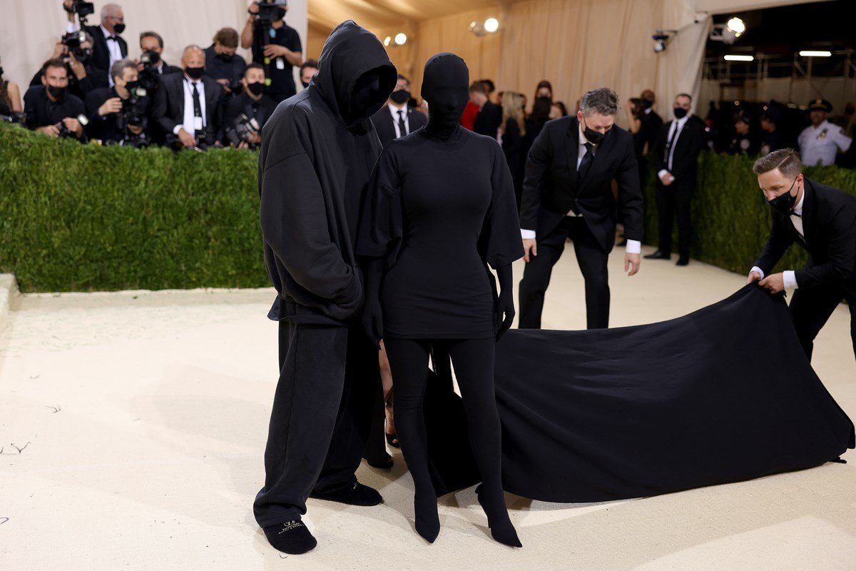 A empresaria Kim Kardashian e o estilista Demna Gvasalia, da Balenciaga, no evento Met Gala de 2021. Ambos usam roupas pretas, com máscaras que cobre seus rostos. - Metrópoles
