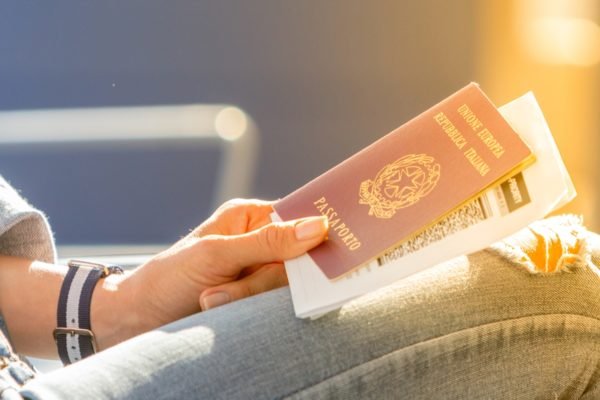 Mulher segurando passaporte italiano - Metrópoles