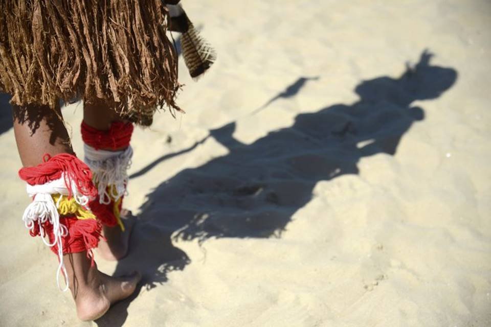 Foto colorida de pés de um indígena Pataxó andando na areia - Metrópoles