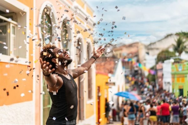 Imagem colorida: homem joga confetes para o alto no Carnaval de Olinda - Metrópoles