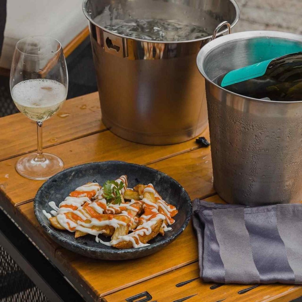 Na foto, uma mesa com batatas e vinho - Metrópoles