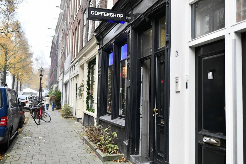 Foto de uma das ruas de Amsterdã em que mostra uma cafeteria da cidade que vende maconha 