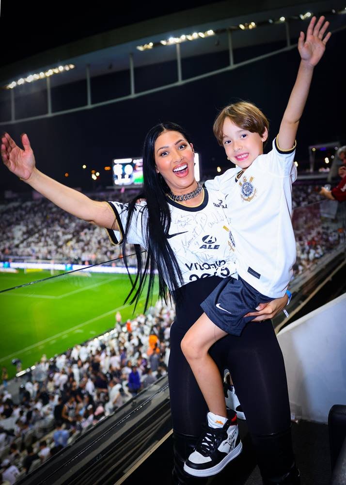 Foto colorida de Simaria e filhos em estádio