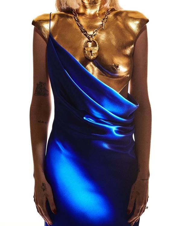 Look com armadura anatônica dourada com vestido azul por cima - Metrópoles