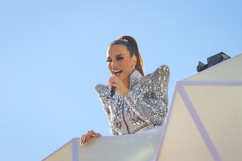 foto colorida de ivete sangalo de roupa prateada cantando - metrópoles
