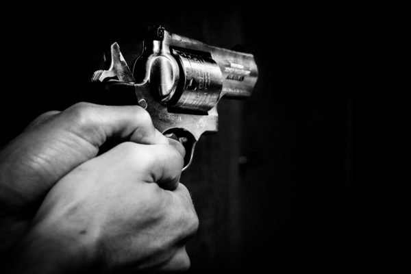 Imagem preto e branco de homem segurando pistola criança MT