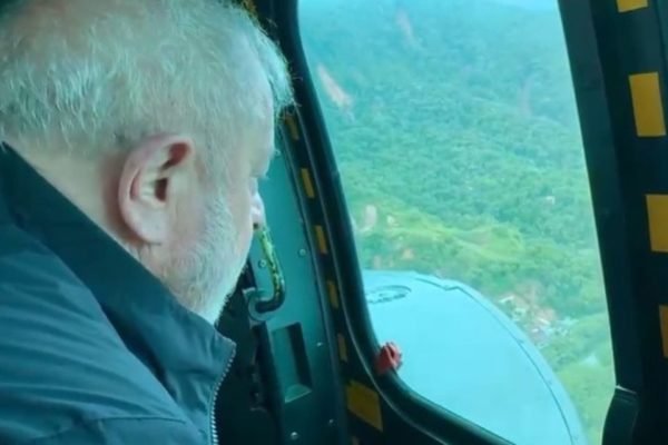 Foto colorida do presidente Lula sobrevoando área atingida por chuvas em SP