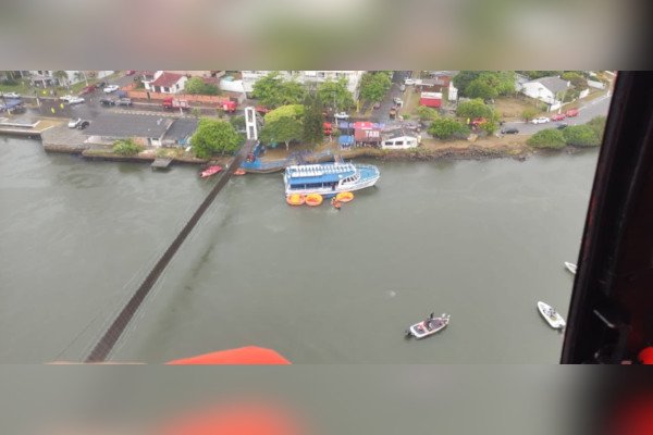 visão aérea de rio com barco de teto azul perto de ponte