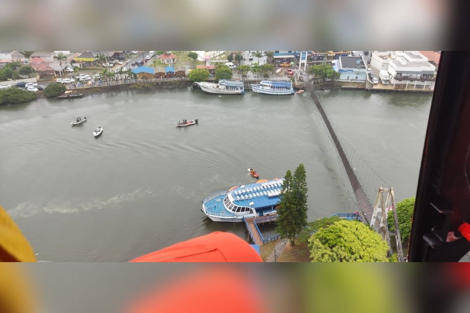 visão aérea de rio com barco de teto azul perto de ponte