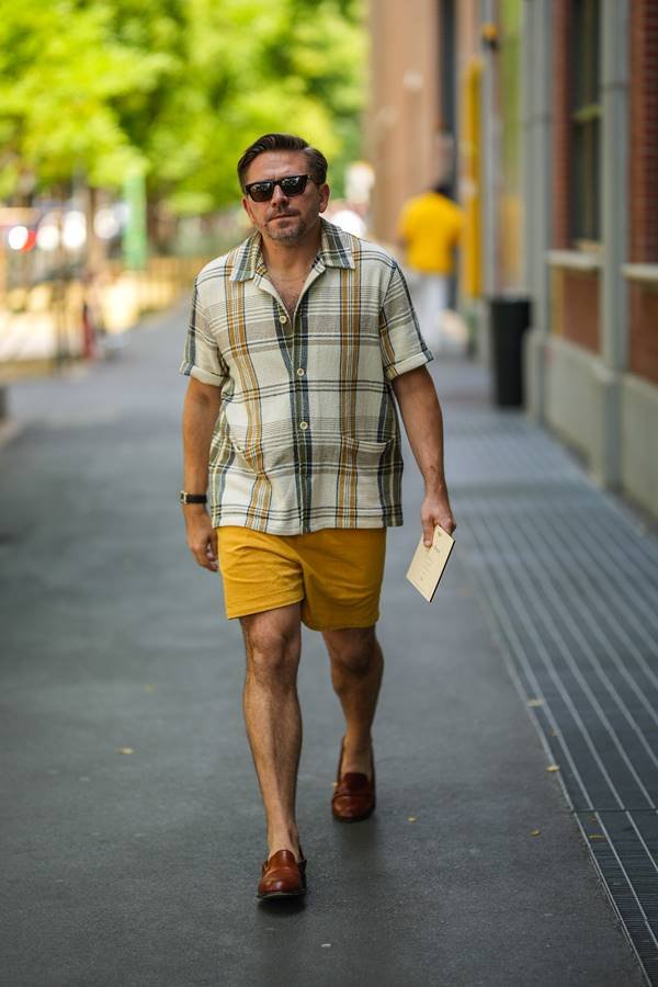 Homem com roupa mostarda caminhando na rua - Metrópoles