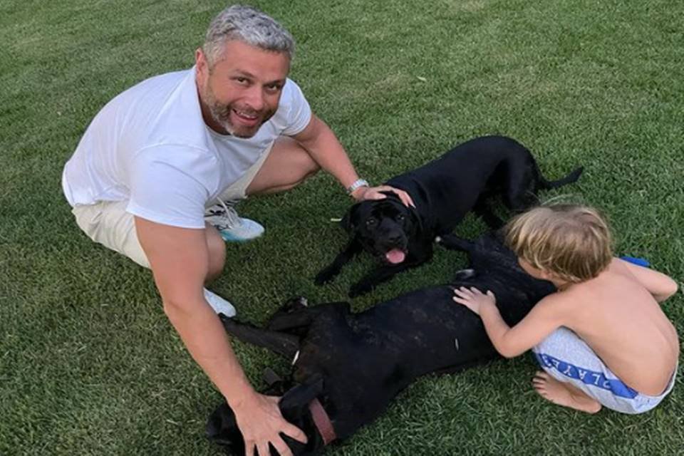 Prefeito de Barra Mansa (RJ), Rodrigo Drable, brinca com dois cachorros pretos e uma criança loira