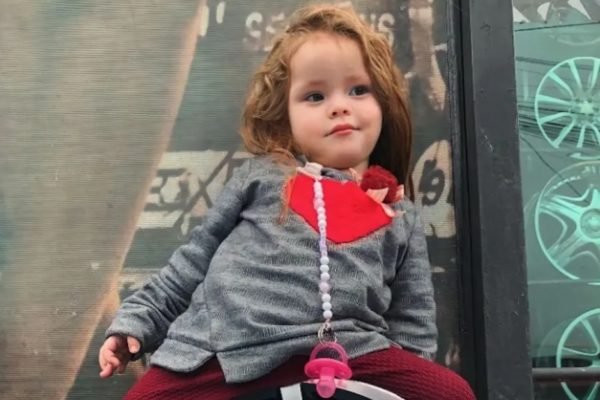 Imagem colorida: menina de 2 anos sentada - Metrópoles