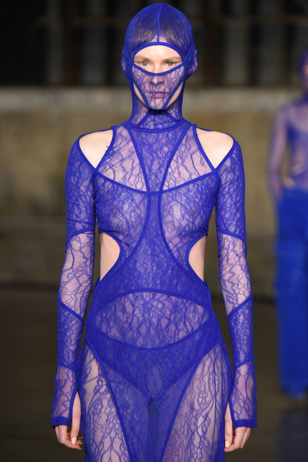 Desfile da coleção de outono/inverno 2023 da marca Dion Lee na Semana de Moda de Nova York. A modelo é um mulher jovem e branca e usa um vestido azul de renda que cobre o rosto também. - Metrópoles