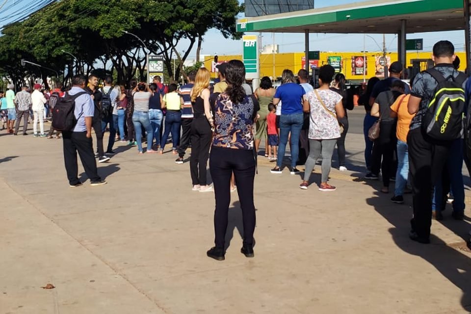 Imagem colorida mostra dezenas de pessoas em parada de ônibus por causa de defeito no metrô - Metrópoles
