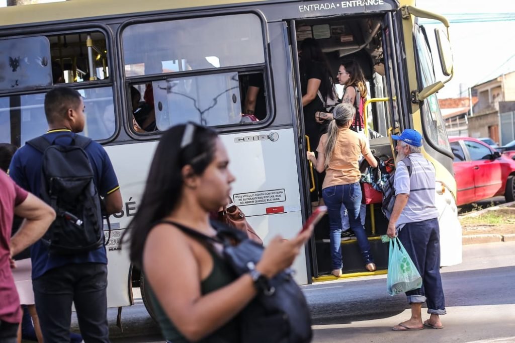 Passageiros entrem em ônibus lotado
