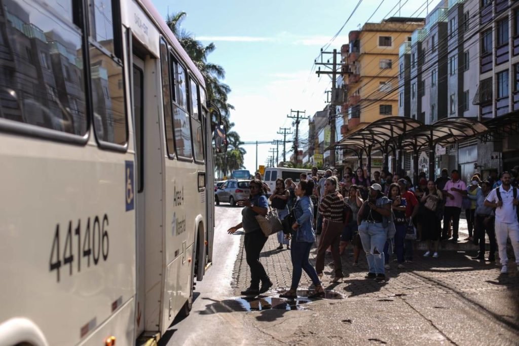 Passageiros fazem fila para entrar em ônibus lotado