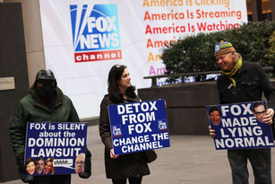 Fotografia colorida de manifestantes protestanto contra a Fox News pela difusão de teoria conspiratória de fraude eleitoral